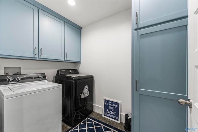 clothes washing area featuring cabinets and independent washer and dryer