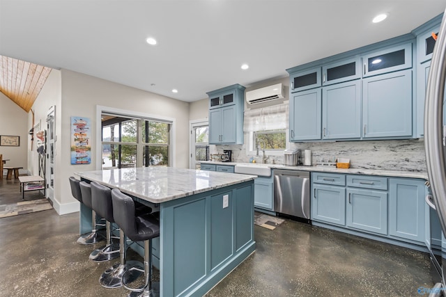 kitchen with a wall mounted air conditioner, a kitchen island, blue cabinetry, and stainless steel dishwasher