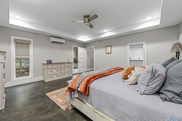 bedroom featuring ceiling fan, a wall unit AC, and a tray ceiling