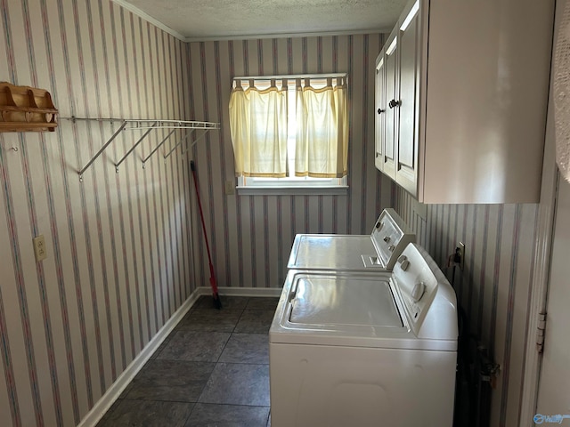 washroom featuring cabinets, a textured ceiling, and washing machine and clothes dryer