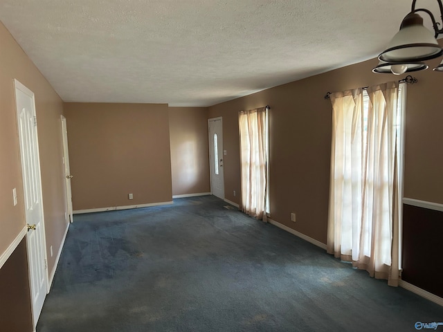 carpeted spare room with a textured ceiling