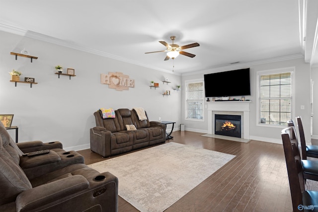 living room with a fireplace with flush hearth, crown molding, ceiling fan, and a wealth of natural light