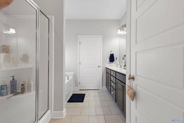 full bathroom with baseboards, a shower stall, vanity, tile patterned flooring, and a garden tub