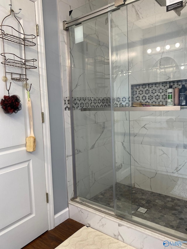 bathroom with an enclosed shower and hardwood / wood-style floors