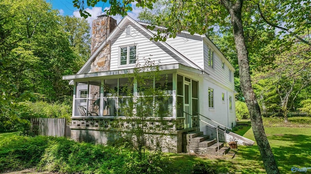 view of front facade with a sunroom and a front yard