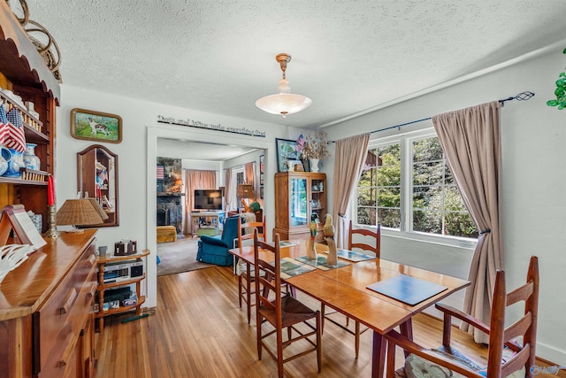 dining area with a textured ceiling and wood-type flooring