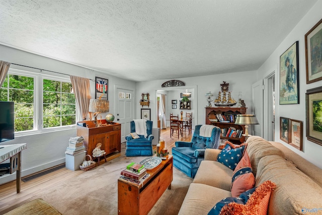living room featuring a textured ceiling, visible vents, and wood finished floors