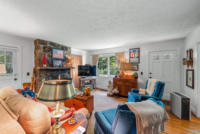 living room with a textured ceiling, wood-type flooring, and a fireplace