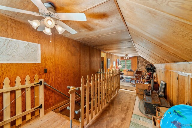 interior space with lofted ceiling, wood ceiling, wood walls, ceiling fan, and wood finished floors
