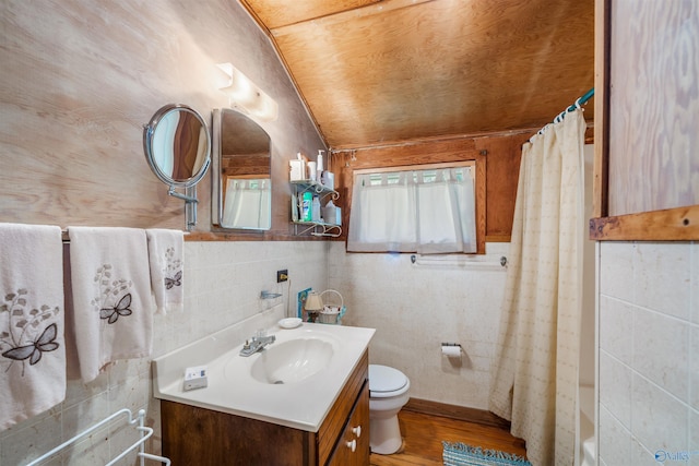 bathroom with a shower with curtain, a tub to relax in, toilet, wood finished floors, and vanity