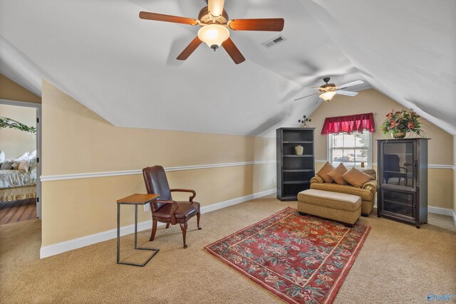 living area featuring lofted ceiling, ceiling fan, and light carpet