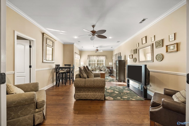 living area featuring baseboards, visible vents, a ceiling fan, ornamental molding, and dark wood-style flooring