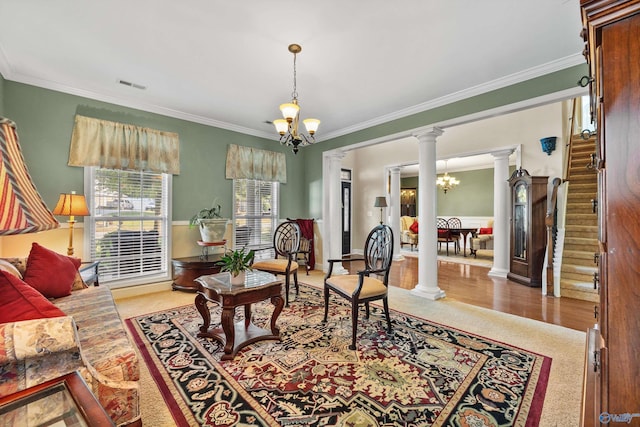 living area with an inviting chandelier, decorative columns, stairs, and visible vents