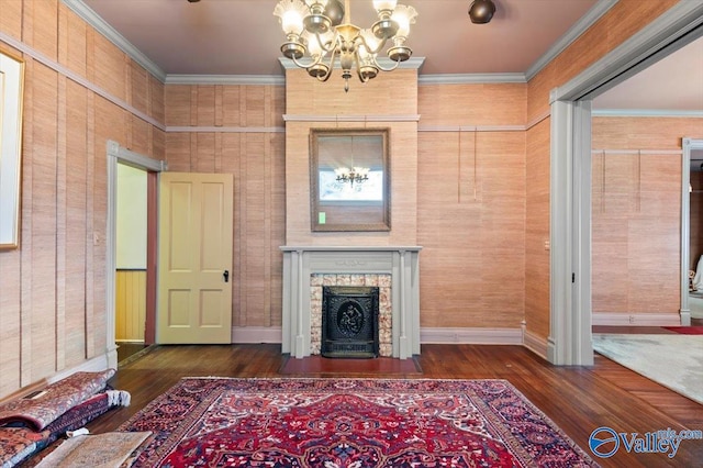 unfurnished living room featuring dark wood-type flooring, a notable chandelier, and ornamental molding