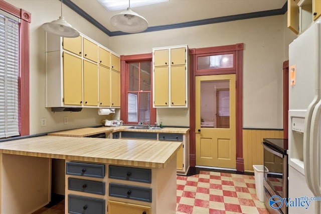 kitchen featuring crown molding, white refrigerator with ice dispenser, sink, decorative light fixtures, and electric stove