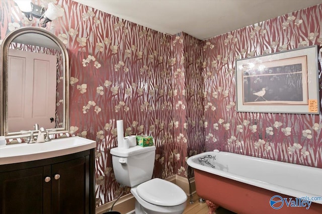 bathroom featuring a washtub, toilet, and vanity