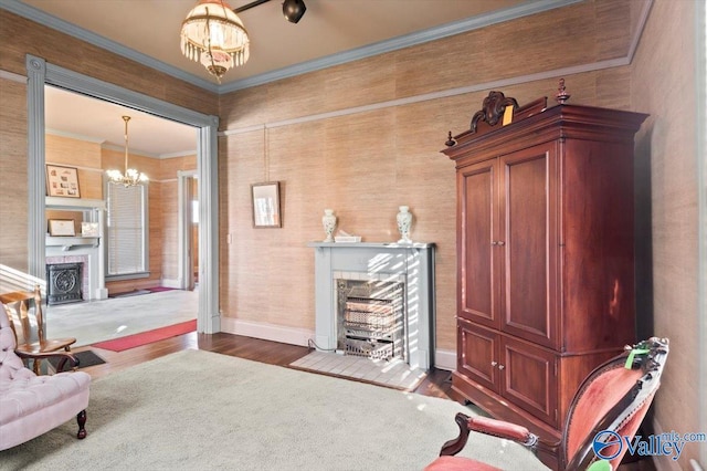 living area featuring dark hardwood / wood-style floors, crown molding, and a notable chandelier