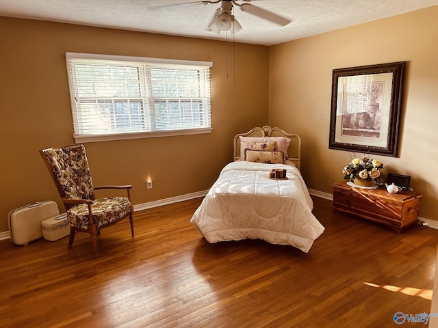 bedroom with wood-type flooring, a textured ceiling, and ceiling fan