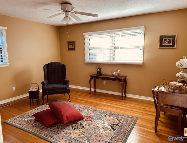 sitting room featuring ceiling fan, a textured ceiling, and hardwood / wood-style flooring