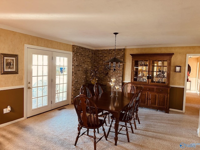 dining area with light colored carpet, crown molding, and a notable chandelier