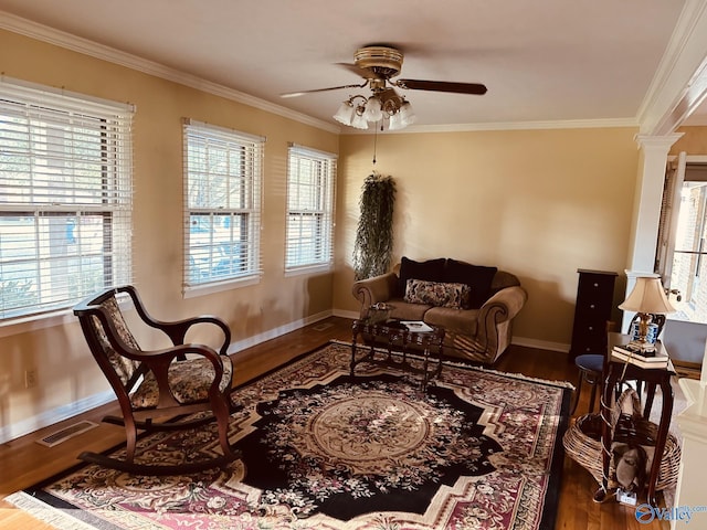 sitting room featuring decorative columns, a wealth of natural light, ornamental molding, and hardwood / wood-style flooring