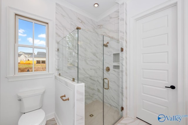 bathroom featuring a shower with door and toilet