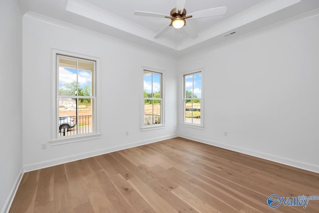 unfurnished room featuring crown molding, ceiling fan, a raised ceiling, and light hardwood / wood-style flooring