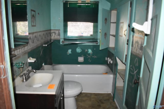 bathroom featuring a tub, vanity, and toilet