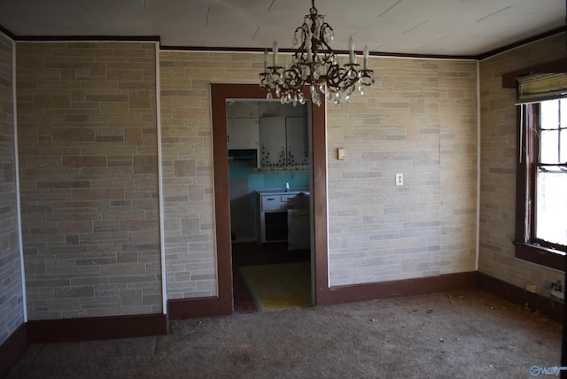 unfurnished room with carpet flooring, ornamental molding, and an inviting chandelier