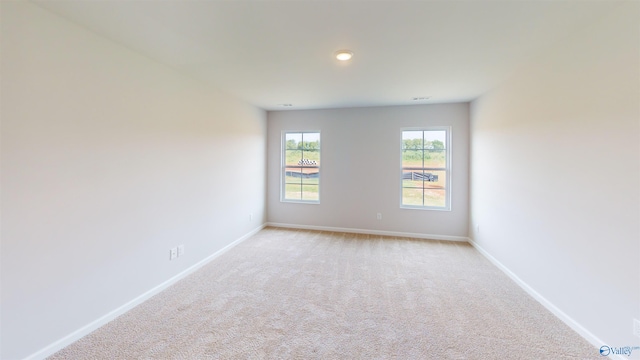 unfurnished room featuring light colored carpet