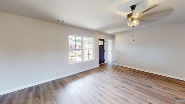 empty room with ceiling fan and light hardwood / wood-style flooring