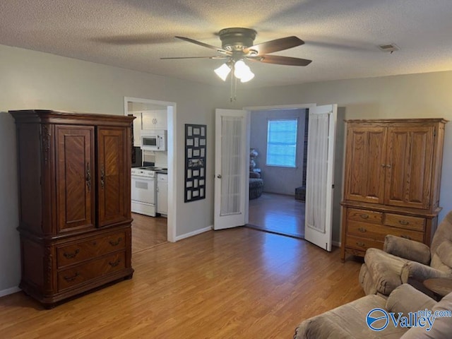 interior space featuring a textured ceiling, ceiling fan, and light hardwood / wood-style flooring