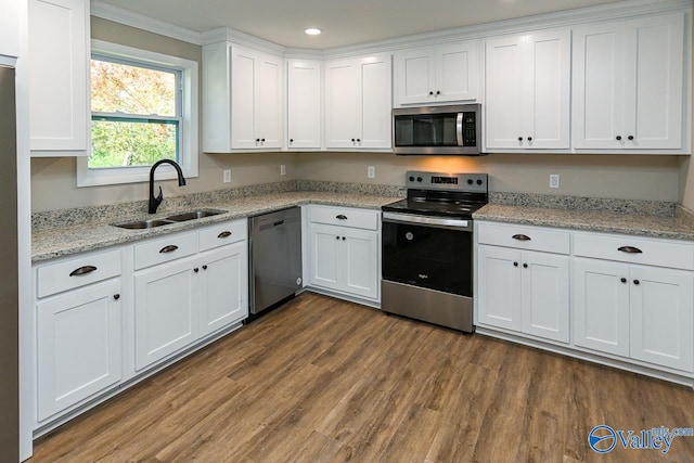 kitchen featuring appliances with stainless steel finishes, ornamental molding, sink, dark hardwood / wood-style floors, and white cabinetry