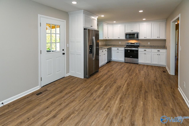 kitchen featuring white cabinets, stainless steel appliances, and dark hardwood / wood-style floors