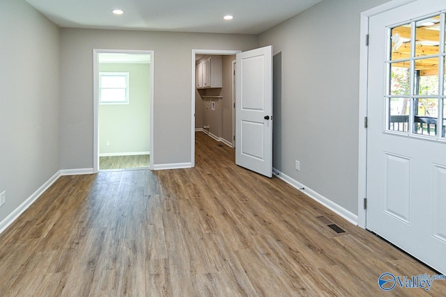 unfurnished bedroom featuring light hardwood / wood-style floors and a walk in closet