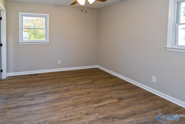 empty room with ceiling fan and dark hardwood / wood-style floors