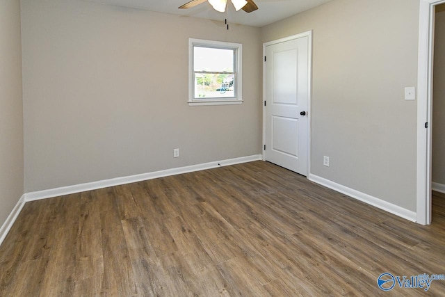 spare room with ceiling fan and dark wood-type flooring