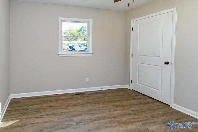 unfurnished room with dark hardwood / wood-style floors and ceiling fan