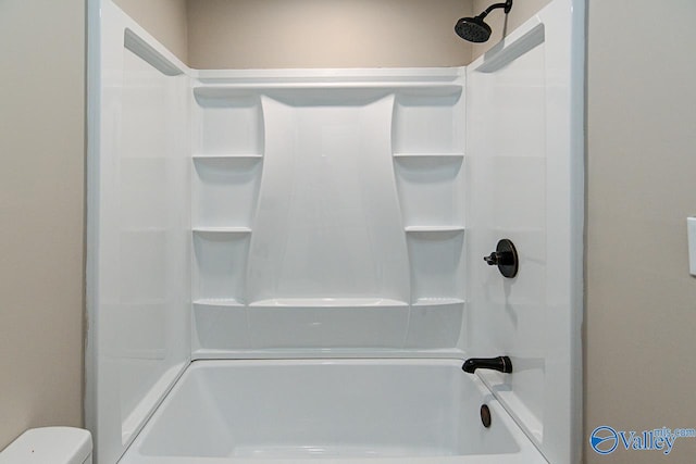 bathroom featuring shower / tub combination and toilet