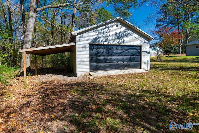 garage with a carport and a lawn