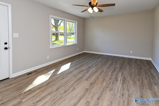 spare room with ceiling fan and dark wood-type flooring