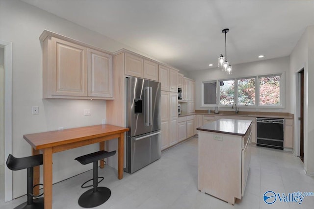 kitchen featuring stainless steel fridge, sink, pendant lighting, dishwasher, and a center island