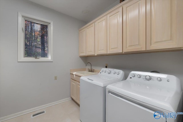 clothes washing area featuring washer and dryer, cabinets, and sink