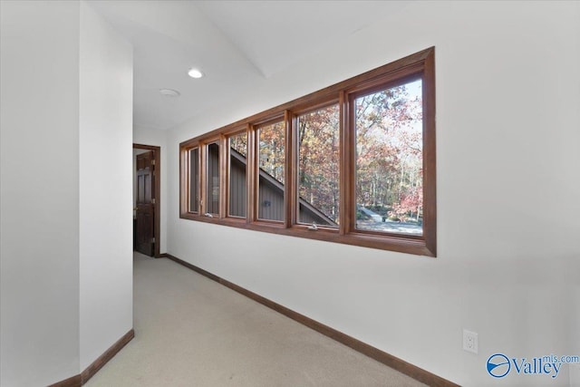 hallway featuring light colored carpet