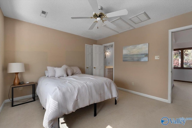 carpeted bedroom with ceiling fan, ensuite bathroom, and a textured ceiling