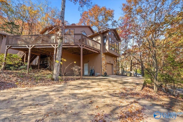 back of house with a wooden deck and a garage