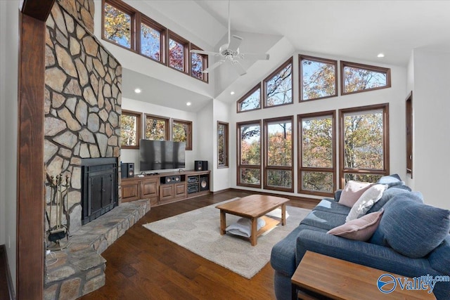 living room featuring ceiling fan, a fireplace, high vaulted ceiling, and wood-type flooring