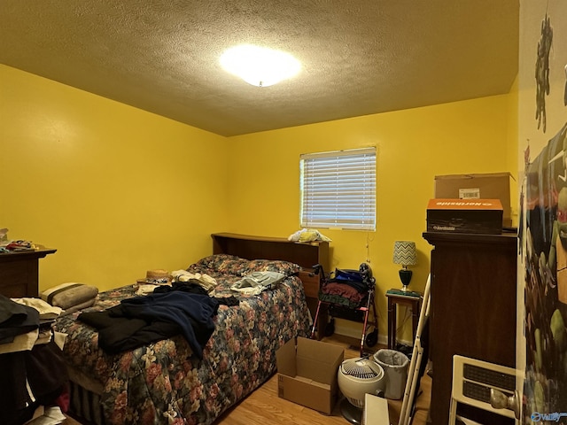 bedroom with light hardwood / wood-style floors and a textured ceiling