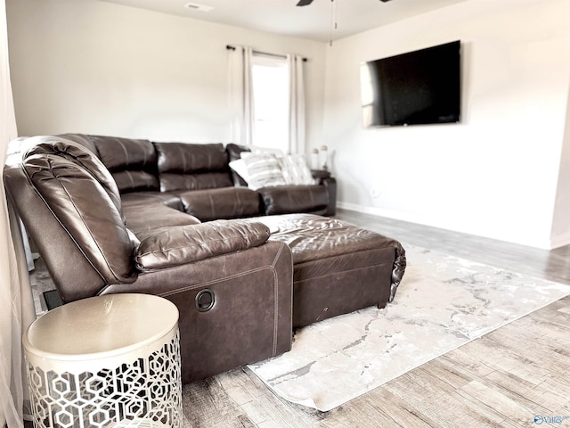 living room featuring hardwood / wood-style floors and ceiling fan