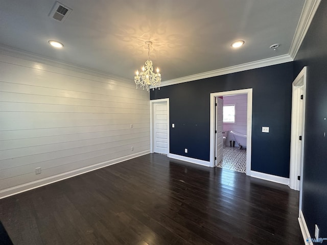 unfurnished room featuring visible vents, a notable chandelier, crown molding, and wood finished floors
